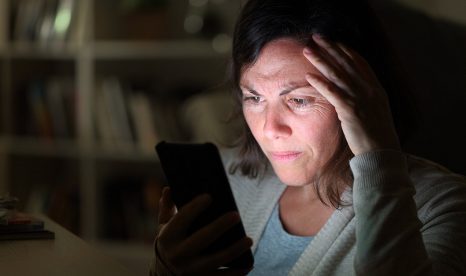 Woman worried watching news on her phone