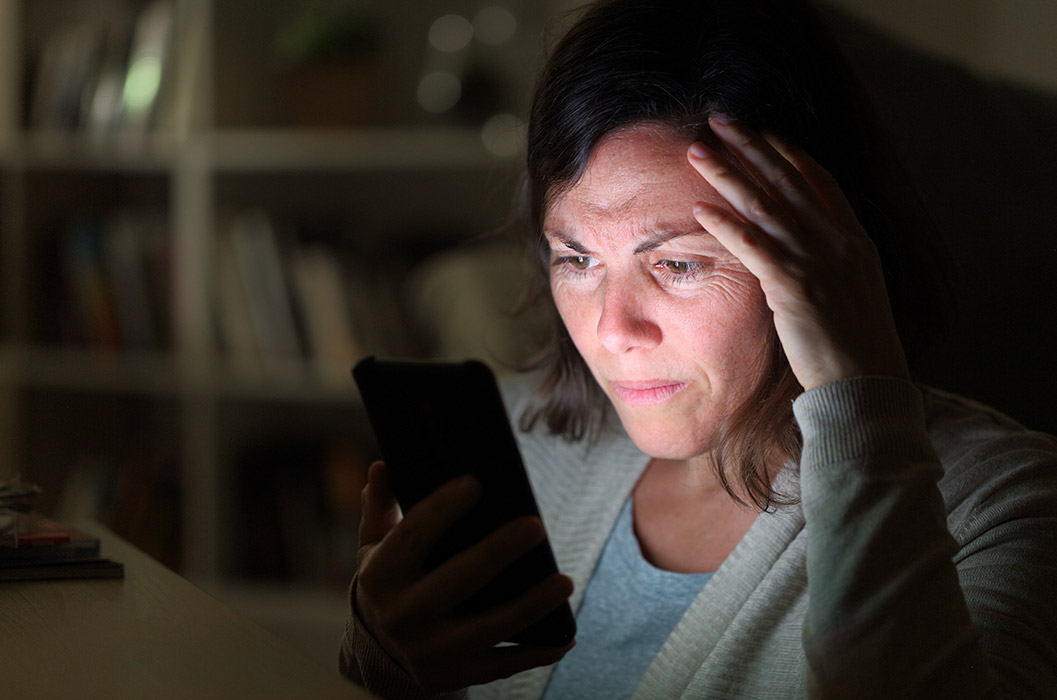 Woman worried watching news on her phone