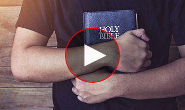 A man holding tight a Bible against his body